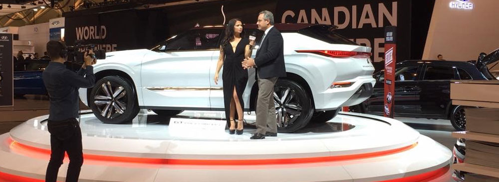 Woman interviewing Mitsubishi PR rep in front of GT PHEV Concept Car